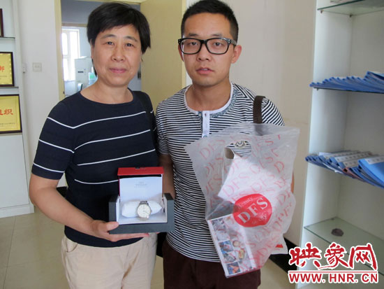 失主王女士從B11車長(zhǎng)吳杰手中拿回自己幫朋友捎的免稅名表 失主王女士從B11車長(zhǎng)吳杰手中拿回自己幫朋友捎的免稅名表