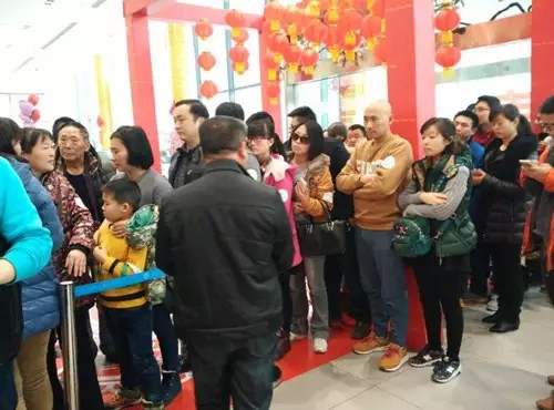 排隊領年貨,一家老小齊上陣。 排隊領年貨,一家老小齊上陣。