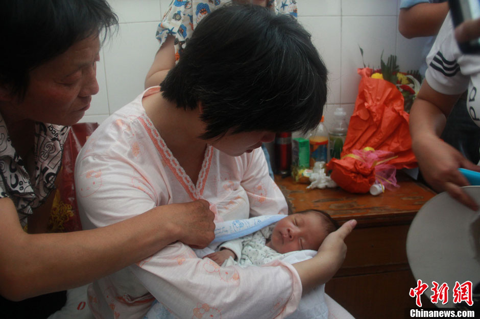 圖為久別重逢,獲救嬰兒母親悉心撫摸愛子。張一辰 攝 圖為久別重逢,獲救嬰兒母親悉心撫摸愛子。張一辰 攝