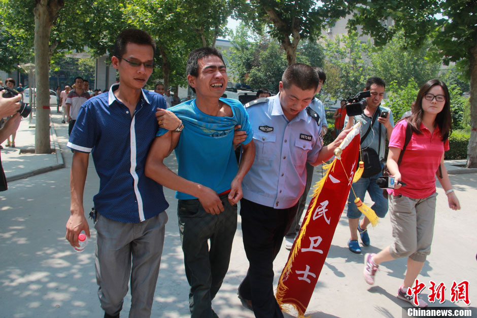 圖為獲救嬰兒父親情緒一度失控,當地警方工作人員對其進行攙扶。張一辰 攝 圖為獲救嬰兒父親情緒一度失控,當地警方工作人員對其進行攙扶。張一辰 攝