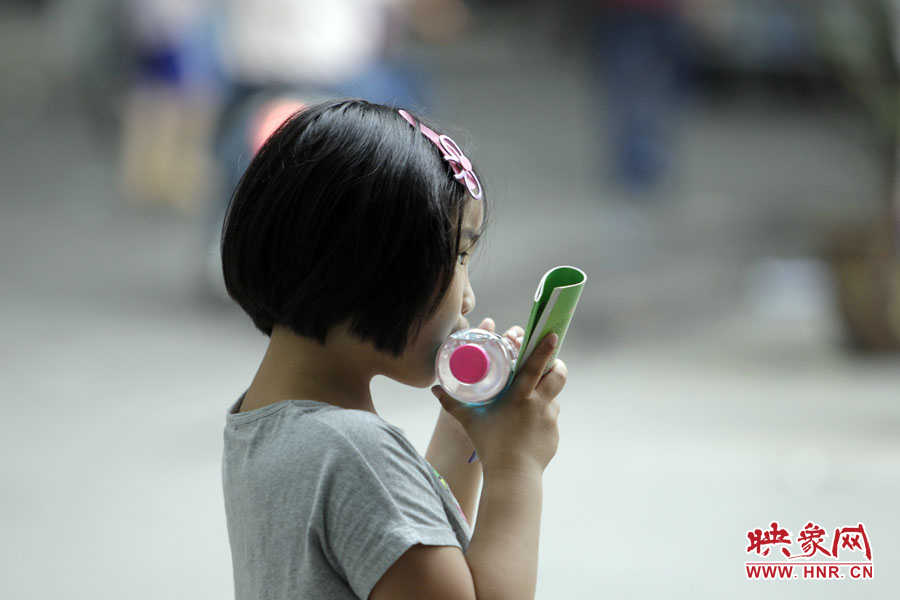 6月7日,鄭州回中考點,一名孩子拿著一瓶礦泉水,等待哥哥走出考場 6月7日,鄭州回中考點,一名孩子拿著一瓶礦泉水,等待哥哥走出考場