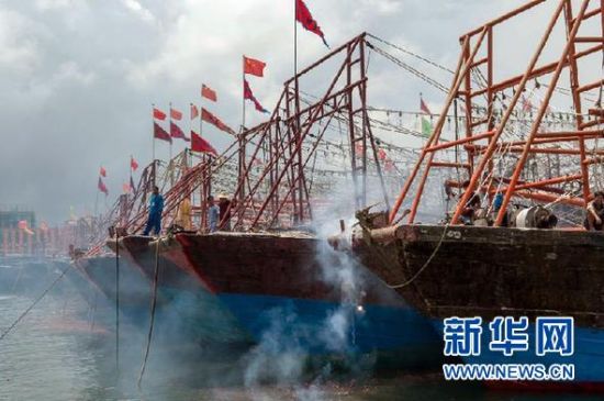 2013年8月1日 南海開漁日 臨高迎新港 8月1日，海南省臨高縣漁民在船上鳴放鞭炮慶祝武蓮港開港。