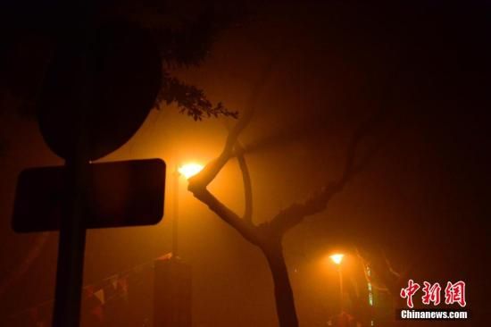 1月31日凌晨，市民行走在煙霧繚繞的南京街頭。當天是農歷馬年正月初一，南京有限開禁燃放煙花爆竹正逢下霧天，空氣的不流通致使煙花爆竹燃燒后產生的顆粒物不能及時散開，造成整座城市煙霧繚繞。據當地環保部門發布的信息顯示，空氣質量屬重度污染。中新社發 泱波 攝