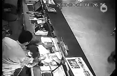 第三名白衣男子沖進柜臺內對女服務員一頓拳打腳踢。 第三名白衣男子沖進柜臺內對女服務員一頓拳打腳踢。