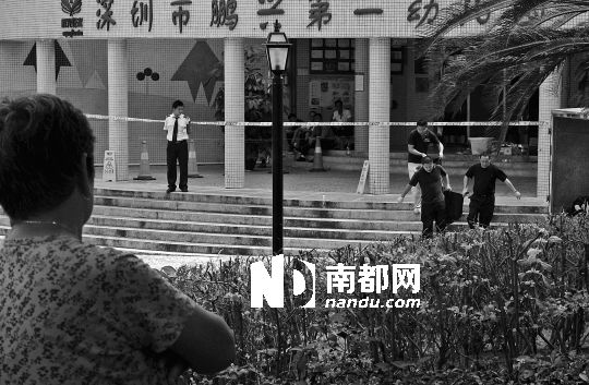 →7月19日，鵬興花園第一幼兒園門前，民警在現(xiàn)場(chǎng)進(jìn)行完勘查取證后，園長(zhǎng)和保安的尸體被運(yùn)走。南都記者 徐文閣 攝