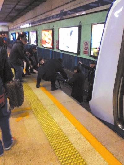 地鐵工作人員將林某從站臺下救起。網友供圖 地鐵工作人員將林某從站臺下救起。網友供圖