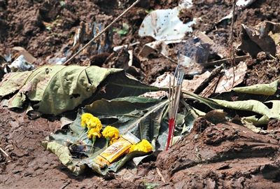 失事現場,有人擺上鮮花放上香燭表示悼念。 失事現場,有人擺上鮮花放上香燭表示悼念。
