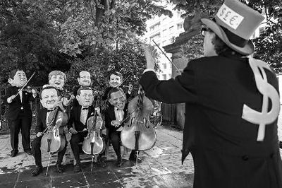 4日在布魯塞爾，非政府組織『樂施會』成員戴著七國首腦面具演奏名曲《錢錢》，批評七國政策導(dǎo)致全球貧富差