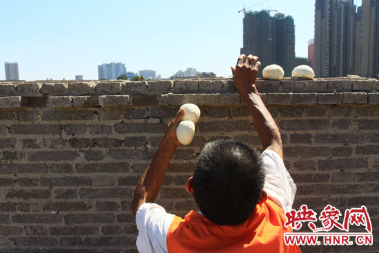 圖為老王在取曬干的饅頭。 圖為老王在取曬干的饅頭。