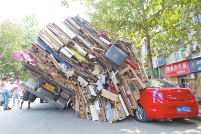 紅色小轎車被砸,卡在路邊動彈不得。 紅色小轎車被砸,卡在路邊動彈不得。