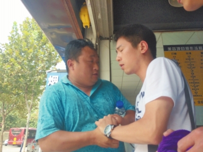 記者正查看照片，突遭藍(lán)衣男強(qiáng)搶手機(jī)。