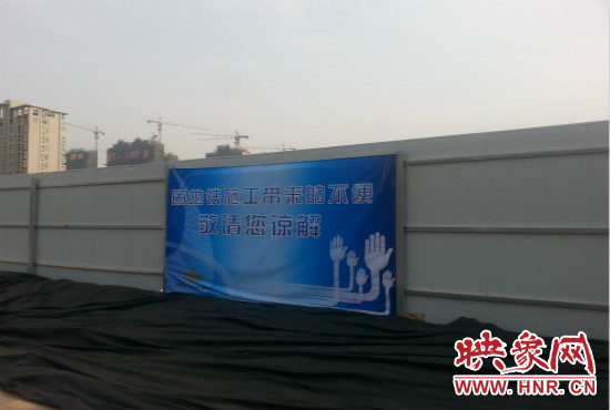 道路南側圍起了白色的圍擋,墻上標示著“因地鐵施工帶來的不便敬請您諒解”的提示牌。 道路南側圍起了白色的圍擋,墻上標示著“因地鐵施工帶來的不便敬請您諒解”的提示牌。