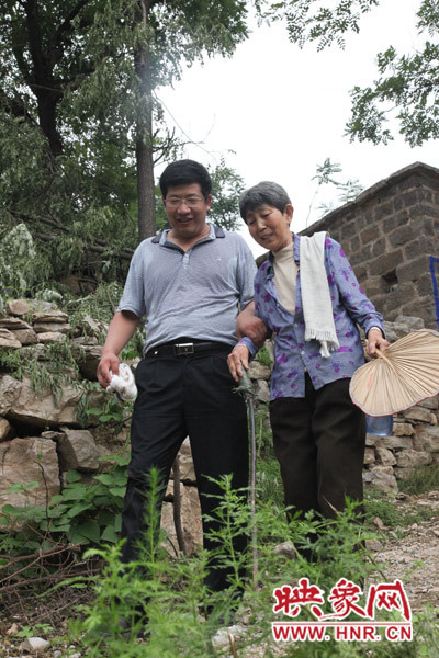 海付恒攙著患有腿部風濕性關節炎的劉梅英下山 海付恒攙著患有腿部風濕性關節炎的劉梅英下山