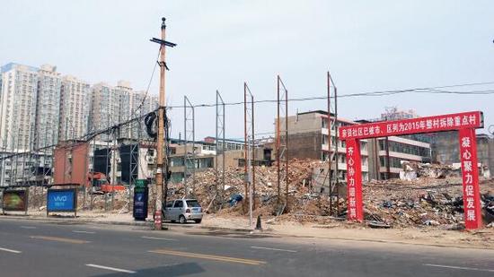 015年5月31日,在社區(qū)干部的帶頭拆遷下,親賢社區(qū)的“城中村改造”拉開帷幕。由于前期“清產(chǎn)核資”及補(bǔ)償標(biāo)準(zhǔn)等因素,拆遷改造工作推進(jìn)并不順利。圖為位于體育西路東側(cè)集體所有的商鋪率先被拆遷完畢,用于遮擋的圍擋正在施工中。(拍攝:2015年9月16日)