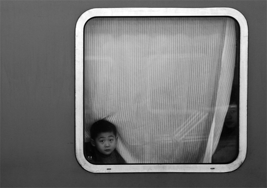 一個孩子把頭伸向窗外,他想再看送別的親人一眼 一個孩子把頭伸向窗外,他想再看送別的親人一眼