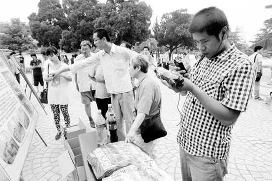 一位市民拿手機掃描商品條形碼，以確認真偽