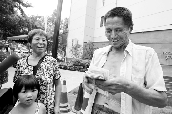 昨日，鄭州市明達路與豐慶路交叉口西300米路南，來自中牟的瓜農拿到西瓜款，笑開顏東方今報記者袁曉強