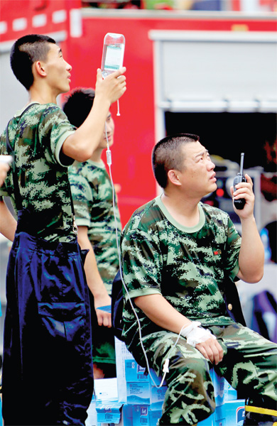 火場外,被消防戰士稱為“李大隊”的救援人員掛著吊瓶現場指揮 火場外,被消防戰士稱為“李大隊”的救援人員掛著吊瓶現場指揮