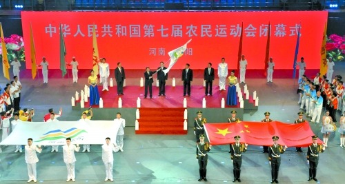 南陽市市長穆為民將農運會會旗遞交到下一屆東道主吉林省松原市市長李相國手里。