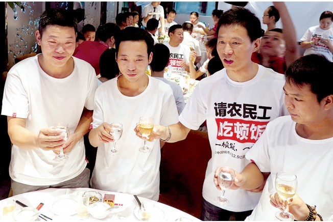 活動發(fā)起人張楠(右二)給農(nóng)民工敬酒。 活動發(fā)起人張楠(右二)給農(nóng)民工敬酒。
