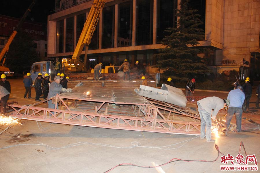 地面上的20多名工人對吊裝下的廣告牌進(jìn)行分割。 地面上的20多名工人對吊裝下的廣告牌進(jìn)行分割。