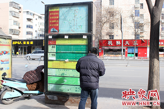 一名男子在貼滿小廣告的公交站牌前駐足 一名男子在貼滿小廣告的公交站牌前駐足