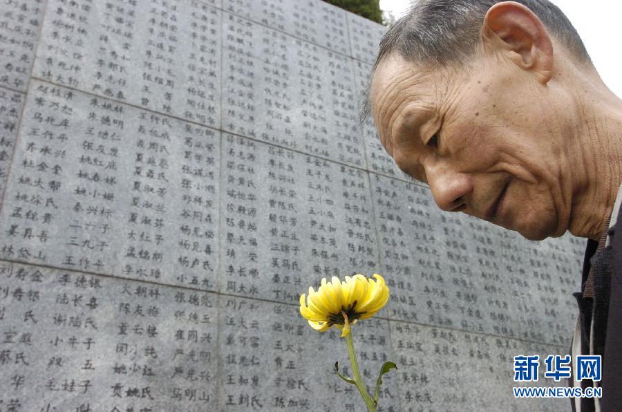 2006年4月5日，74歲的南京大屠殺幸存者佘子清手捧鮮花，祭奠被日軍殺害的母親。