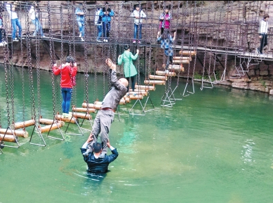 中年男游客正踩著景區安全員郭小明的肩膀過河。網友“@我的小名叫張孩”供圖 中年男游客正踩著景區安全員郭小明的肩膀過河。網友“@我的小名叫張孩”供圖