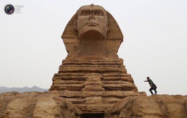 石家莊郊外，一名男子與山寨版獅身人面像合影留念。