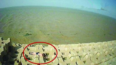 孫正龍游上岸,趴在海邊精疲力盡。 孫正龍游上岸,趴在海邊精疲力盡。