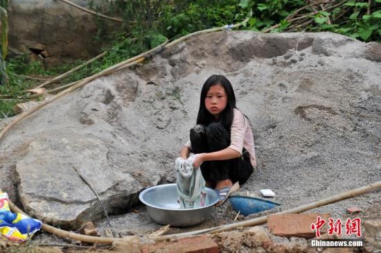 8月9日,云南巧家紅石巖村,10歲的劉鑫蕊在洗自己的衣服 8月9日,云南巧家紅石巖村,10歲的劉鑫蕊在洗自己的衣服