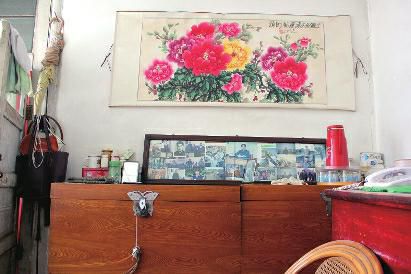 　陳會英將兒女的照片都裱起來，裝在一個大相框里，放在箱子上經?？矗渲凶疃嗟木褪莿⒔饑恼掌?。