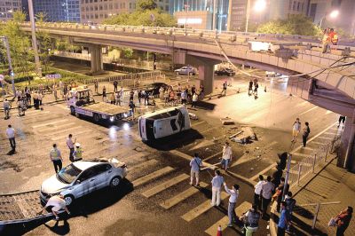 路虎沖下國(guó)貿(mào)橋砸中一輛起亞轎車(chē)，橋上厚達(dá)幾十厘米的水泥護(hù)欄被撞斷，碎石四處散落，數(shù)十群眾在現(xiàn)場(chǎng)圍觀。