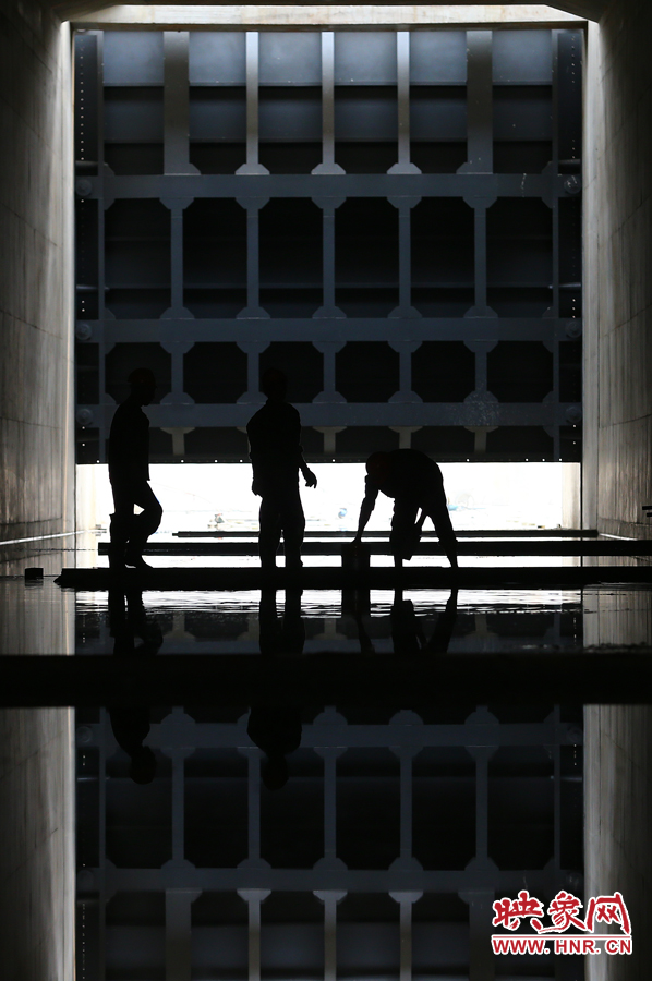 三名工人正在配合著做防水施工 三名工人正在配合著做防水施工