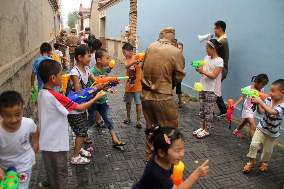 孩子們持水槍打鬼子。 孩子們持水槍打鬼子。