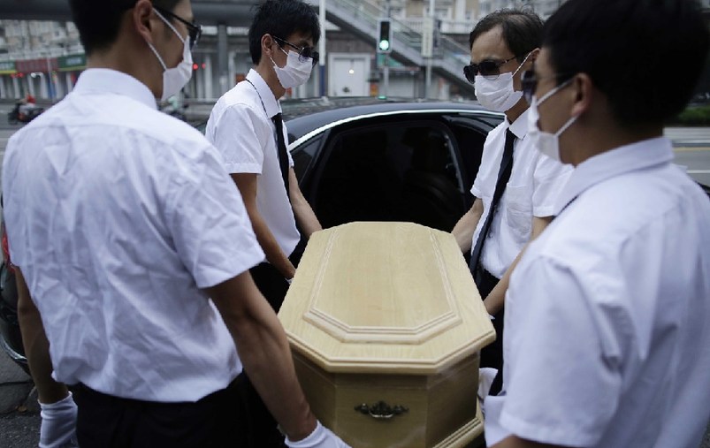 上海，花床、木棺、挽聯，在上海市閔行區一處私密的悼念室內，一場小型追悼儀式正在舉行。