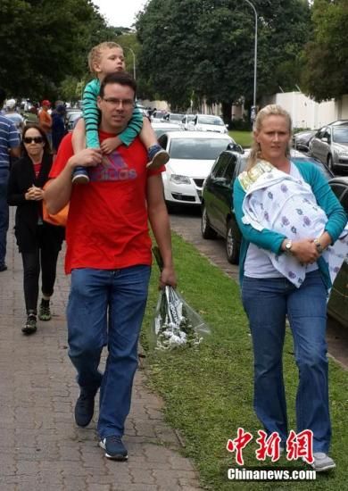 圖為一個白人家庭,由父母帶著孩子到曼德拉家門外悼念。中新社發 宋方燦 攝 圖為一個白人家庭,由父母帶著孩子到曼德拉家門外悼念。中新社發 宋方燦 攝