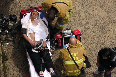 2日，救援人員在美國紐約地鐵事故車輛內(nèi)緊急疏散一名受傷乘客。圖/CFP