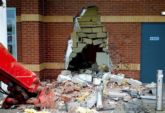 劫匪利用挖掘機的機械臂移走ATM機，留下滿地狼藉