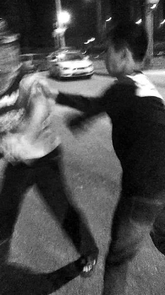 一名男子扯著民警的反光背心一路追打。 一名男子扯著民警的反光背心一路追打。