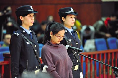 被告人盧梅低著頭,站在朝陽法院刑事審判庭的被告席上。 被告人盧梅低著頭,站在朝陽法院刑事審判庭的被告席上。