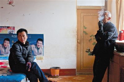 父親抽煙,兒子不語。逃跑的越南新娘,給袁迎賓父子帶來的是失落。新京報記者 周崗峰 攝 父親抽煙,兒子不語。逃跑的越南新娘,給袁迎賓父子帶來的是失落。新京報記者 周崗峰 攝