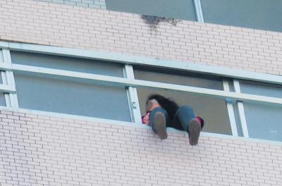 28樓的窗臺(tái)上坐著一名女子，其兩條腿耷拉在室外，不停地?cái)[動(dòng)。