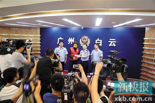 因舉報涉毒案件線索而獲獎的“快遞小哥”戴著面具領取獎金。