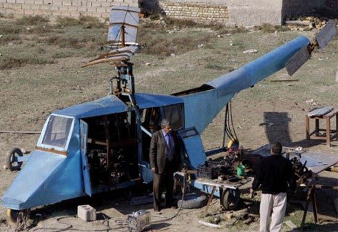 哈蒂姆·卡迪姆·薩爾曼正與工人交談，背后就是他正在制造的直升機(jī)