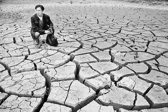 蹲在干涸的田地里,焦裕祿為饑餓的百姓揪心不已 《焦裕祿》劇照 蹲在干涸的田地里,焦裕祿為饑餓的百姓揪心不已 《焦裕祿》劇照